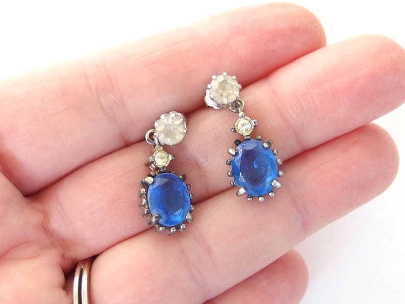 vintage Avon blue crystal glass set includes a necklace whose pendant may be used as a brooch, an adjusting ring, and a pair of dangle post earrings.