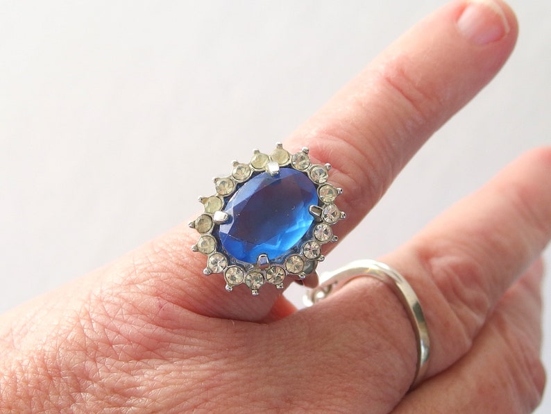 vintage Avon blue crystal glass set includes a necklace whose pendant may be used as a brooch, an adjusting ring, and a pair of dangle post earrings.