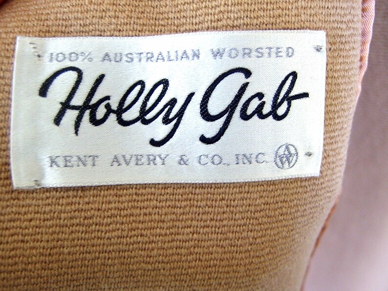 May include: A white label with black text that reads "100% Australian Worsted Holly Gab Kent Avery & Co., Inc.".