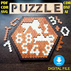 Puede incluir: Rompecabezas de madera con diseño de panal. El rompecabezas presenta una forma hexagonal con piezas individuales y la palabra "PUZZLE" recortada en la parte superior. Las piezas del rompecabezas son en tonos marrones y blancos. También se ven las palabras "PDF CDR SVG" y "CDR DXF AI".