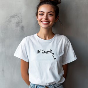Puede incluir: Una camiseta blanca con el texto "in control" escrito en negro en la parte delantera.