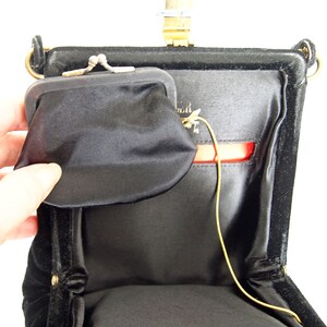Puede incluir: Bolso de noche de terciopelo negro con cierre dorado y monedero a juego. El bolso tiene una correa de cadena dorada y un forro de sat&eacute;n rojo.