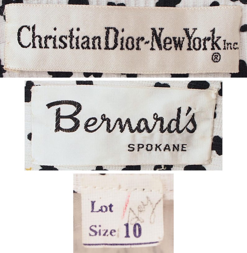 K&ouml;nnte beinhalten: Nahaufnahme von drei Kleidungsetiketten. Das obere Etikett lautet "Christian Dior-New York Inc." in schwarzem Text auf cremefarbenem Hintergrund. Das mittlere Etikett lautet "Bernard's Spokane" in schwarzer Schrift. Das untere Etikett lautet "Lot" und "Size 10".