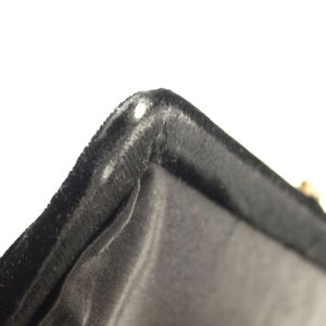 Puede incluir: Primer plano del forro de terciopelo negro de una caja. El forro es suave y mullido, con un brillo sutil.