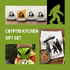 May include: A Cryptid Kitchen gift set featuring four whiskey glasses with a black and white illustration of a Bigfoot being abducted by a UFO, a white kitchen towel with a similar design, and a bowl of brown candy.