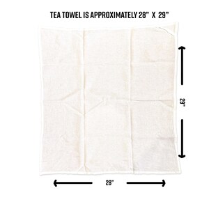 Puede incluir: Un pa&ntilde;o de cocina rectangular de color blanco roto con una textura tejida visible. La imagen incluye flechas negras y texto que indica las dimensiones de aproximadamente 28 pulgadas por 29 pulgadas, con el texto TEA TOWEL IS APPROXIMATELY 28" X 29".