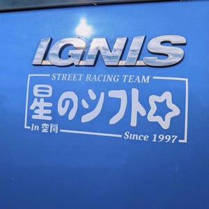 May include: A close-up of a blue car surface with the chrome letters "IGNIS" at the top. Below, a white graphic reads "STREET RACING TEAM" and Japanese text. The graphic includes a star and the text "Since 1997."