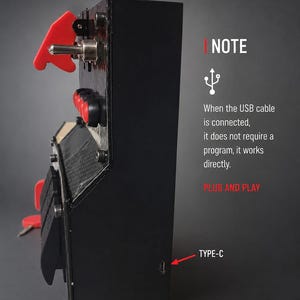 May include: A black rectangular control box featuring a red toggle switch, red push buttons, and a red ignition key. The side panel displays a USB Type-C port. Text on the side reads: NOTE, When the USB cable is connected, it does not require a program, it works directly. PLUG AND PLAY.