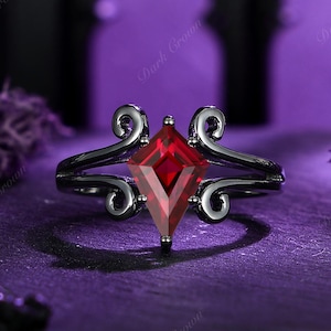 May include: A black ring with a red, diamond-shaped gemstone. The ring features decorative swirls on either side of the gemstone. The background is a dark purple, with the words "Dark Crown" visible.