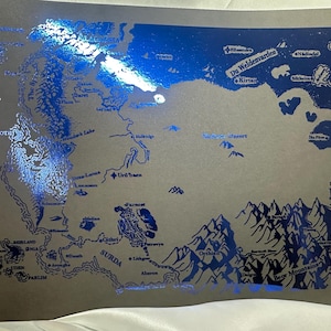 Puede incluir: Una impresión en lámina azul y plateada de un mapa de fantasía con el texto "Du Weldenvarden" y "Kirtlar".