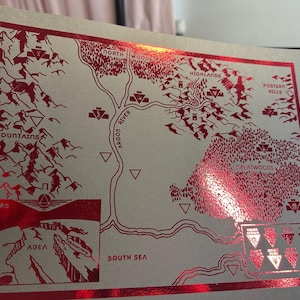 May include: A red and white map with the words "Mars", "South Sea", "Greatwoods", "Highlands", "Northern Woods", "Argos River", "Mountains", and "Postern Mills".