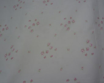 May include: White fabric with a scattered pattern of small pink flowers.