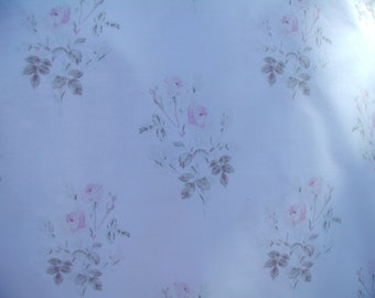 May include: A light blue background with a repeating pattern of pink and white roses with green leaves.
