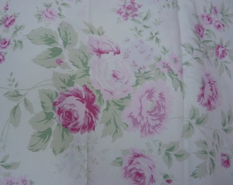 May include: White fabric with a floral pattern featuring large pink and fuchsia roses, smaller pink flowers, and green leaves. The design is a repeating pattern of romantic, classic floral elements.