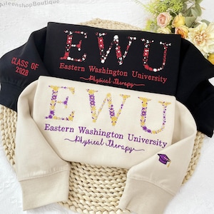 May include: Two sweatshirts, one black and one beige, with embroidered text. The black sweatshirt features "EWU" in floral letters and "Eastern Washington University Physical Therapy." The beige sweatshirt has the same design. The black sweatshirt also has "Class of 2028."