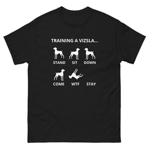 May include: Black t-shirt with a white graphic of a dog in different poses with the text "Training a Vizsla..." and the words "Stand, Sit, Down, Come, WTF, Stay" underneath each pose.