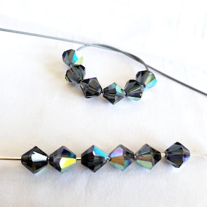 Dodici perle di cristallo bicono Morion AB da 6 mm, articolo Swarovski ritirato n. 5301 perle bicono sfaccettate, aurora boreale grigio antracite OOP