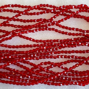 Peut inclure: Un brin de perles de verre facettées rouges. Les perles sont petites et ont une finition brillante.