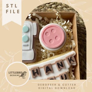 May include: A box of decorated cookies, including a sewing machine, a button, and a banner that says "Thank You." The cookies are white, pink, and light blue. The text "STL FILE" and "DEBOSSER & CUTTER DIGITAL DOWNLOAD" are also visible.