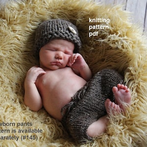 Puede incluir: Un bebé recién nacido con un gorro marrón tejido con un botón de madera y pantalones a juego. El bebé está acostado sobre una superficie suave de color amarillo. El texto en la imagen dice "knitting pattern pdf" y "Newborn pants pattern is available separately (#145)".