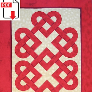 Op de afbeelding: Een rood en crèmekleurig quilt met een centraal ontwerp van verweven knopen. Het ontwerp wordt omlijst door een rode rand. Het PDF-pictogram staat in de linkerbovenhoek.