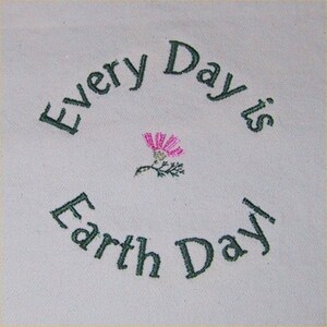 May include: Embroidered design on a white fabric background. The design features a pink flower with green leaves and the text "Every Day is Earth Day".