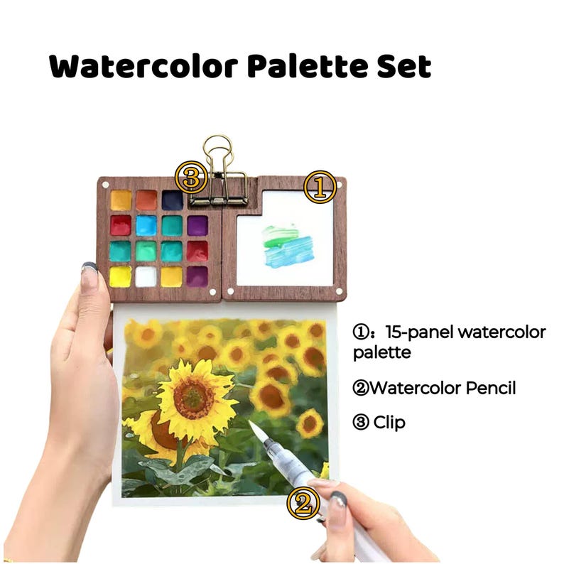 May include: A watercolor palette set with 15 paint pans, a watercolor pencil, and a clip. The palette is made of wood and has a clear plastic lid. The watercolor pencil is white and has a black tip. The clip is silver and has a black handle.