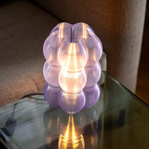 Yoli: Luminária de mesa, cabeceira e escrivaninha moderna. Luz ambiente, original e suave. Disponível em rosa, vermelho, azul, verde, roxo e amarelo, com formato ondulado. Fabricada no Reino Unido. Purple Transparent