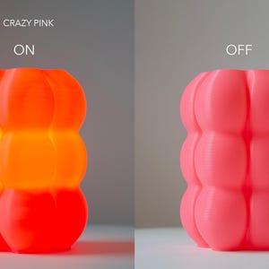 Pode incluir: Uma l&acirc;mpada rosa bulbosa com uma superf&iacute;cie texturizada. A l&acirc;mpada est&aacute; acesa na imagem da esquerda e desligada na imagem da direita. O texto "COLOUR: CRAZY PINK" est&aacute; acima da l&acirc;mpada na imagem da esquerda. O texto "ON" est&aacute; acima da l&acirc;mpada acesa e o texto "OFF" est&aacute; acima da l&acirc;mpada desligada.