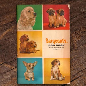 May include: A vintage Sergeant's Dog Book with a grid of colorful panels featuring various dog breeds. The cover displays illustrations of a spaniel, two puppies, two dachshunds, a chihuahua, and a beagle, with the title text clearly printed.