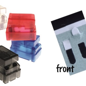 Peut inclure: Quatre boîtes en plastique transparent, une en rouge, une en bleu, une en noir et une transparente. Les boîtes sont empilées les unes sur les autres. Les boîtes ont une petite ouverture en haut et une petite ouverture en bas. Les boîtes sont étiquetées "avant" et "arrière".