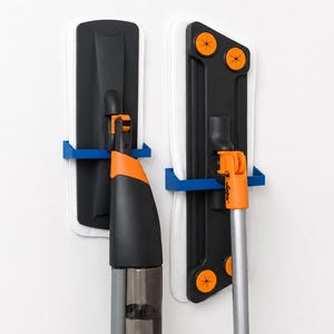 Könnte beinhalten: Zwei Flachwischer mit schwarzen und orangefarbenen Kunststoffköpfen und weißen Mikrofasertüchern, jeweils in einer blauen Wandhalterung befestigt. Der linke Wischer hat einen Sprühmechanismus, der rechte verfügt über vier orangefarbene Befestigungen.