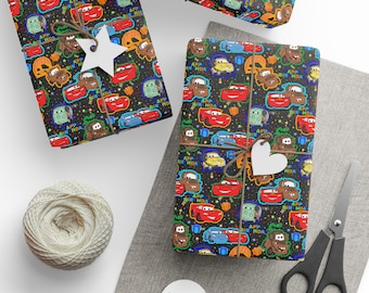 May include: Wrapped gifts featuring a car-themed pattern on black paper, tied with twine and decorated with star and heart tags. A ball of twine, scissors, and blank tags are also visible. The wrapping paper has the text "APP BIR HOA".