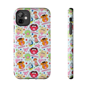 May include: A light blue iPhone case with a repeating pattern of Muppet characters, including Kermit the Frog, Fozzie Bear, and Miss Piggy. The design includes the word "Bubbly" and pink bubble accents. The case is shown from the front and side.