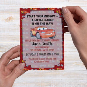 May include: A red and white baby shower invitation featuring a cartoon race car. The invitation reads "Start Your Engines - A Little Racer Is On The Way!" and includes details for a shower honoring Jane Smith.