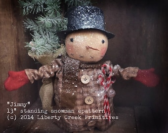 May include: A 13-inch standing snowman doll with a black top hat, brown plaid coat, red mittens, and a candy cane. The snowman is holding a small burlap sack and a small bird. The doll is covered in white glitter to resemble snow.