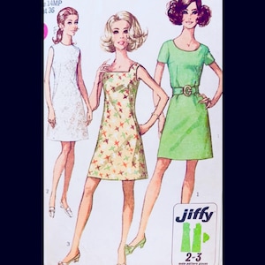 May include: Vintage sewing pattern featuring three dresses. One is white with lace, another is yellow with star patterns, and the third is green with a belt. The pattern is labeled "Jiffy" and includes sizes 2-3.