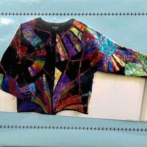 May include: A black jacket with a vibrant, abstract patchwork design. The jacket features a variety of colors including blue, purple, orange, and green, with red thread accents. The design is reminiscent of stained glass or a mosaic.