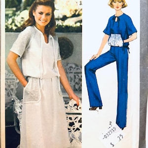 Könnte beinhalten: Ein Bild mit einer Frau in einem weißen Kleid und einer passenden kurzärmeligen Jacke. Das Kleid hat Taschen mit einem transparenten Overlay. Daneben eine Zeichnung eines blauen Jumpsuits mit passendem Oberteil und einer kleinen weißen Handtasche.