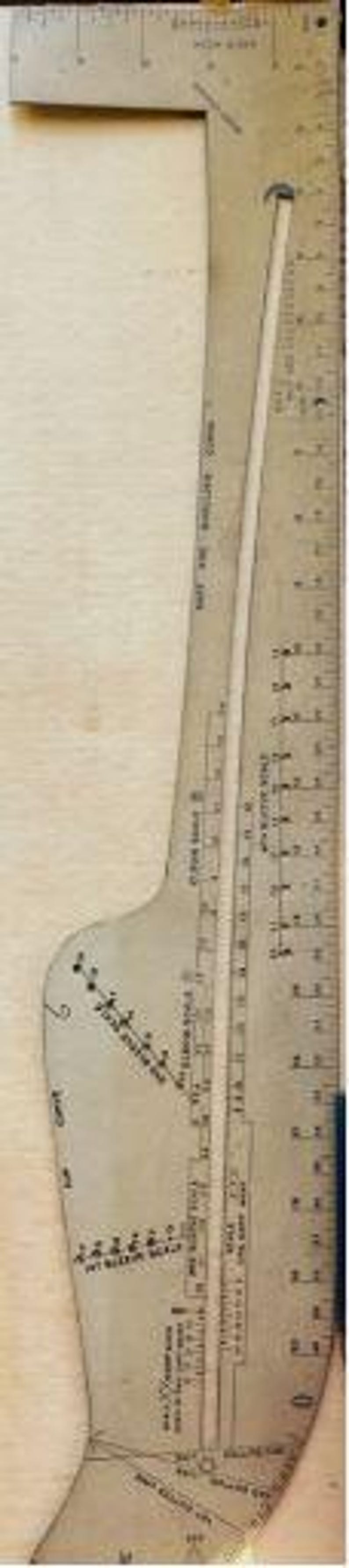 May include: A metallic L-shaped tailor's square and curve ruler featuring various measurement scales, including a bust and shoulder curve, armhole scale, and hip measure scale. The tool displays imperial markings in inches along its edges.