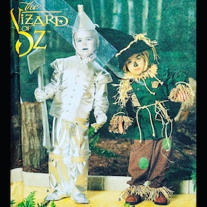 Puede incluir: Un patrón vintage para un disfraz infantil del Hombre de Hojalata y el Espantapájaros del Mago de Oz. El disfraz del Hombre de Hojalata es plateado y el disfraz del Espantapájaros es verde con pantalones marrones y detalles de paja.