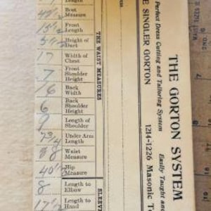 May include: A beige paper measure pad for the Gorton System, featuring printed categories for neck, waist, and sleeve measurements with handwritten numerical entries. The text includes Josephine Singler Gorton and Chicago, Illinois address details.