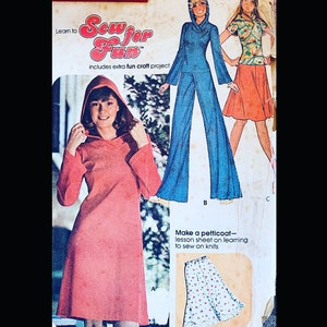 Op de afbeelding: Een vintage naaipatroonboekje met illustraties van drie verschillende capuchonjurken. De tekst op de omslag luidt "Leer naaien voor de lol" en "bevat een extra leuk knutselproject".