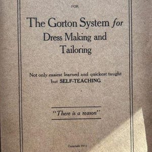 May include: A tan-colored instructional book cover titled The Gorton System for Dress Making and Tailoring. The text includes the phrase Not only easiest learned and quickest taught but SELF-TEACHING, There is a reason, and Copyright 1915.
