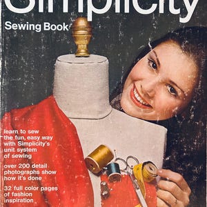 Può includere: Un libro di cucito vintage Simplicity con un manichino bianco, un campione di tessuto rosso, rocchetti di filo, forbici e un metro a nastro giallo. La copertina mostra una persona sorridente e il testo learn to sew the fun, easy way with Simplicity's unit system of sewing, over 200 detail photographs show how it's done, 32 full color pages of fashion inspiration e $1.00.