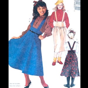 May include: Image of a vintage sewing pattern featuring three different outfits. One outfit includes a blue jumper dress with a brown plaid shirt. Another outfit features a red turtleneck and suspender skirt. The third outfit is a paisley skirt with a white blouse.