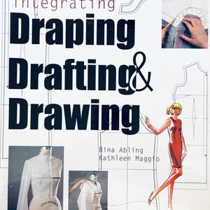 Può includere: Copertina del libro "Integrating Draping Drafting & Drawing" con illustrazioni di manichini, schizzi di moda e una persona che usa uno strumento di disegno. Gli autori sono Bina Abling e Kathleen Maggio.
