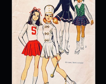 May include: Four girls wearing different outfits. One girl is wearing a white and gold marching band uniform with a hat. Another girl is wearing a red and white cheerleader uniform with an 'S' on the front. A third girl is wearing a black dress with white trim and a red hat. The fourth girl is wearing a green vest over a plaid skirt. All views: Skirt is circular.
