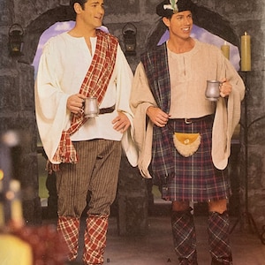 May include: Two men wearing traditional Scottish attire. One man is wearing a kilt, a white shirt, and a brown jacket. The other man is wearing a white shirt, brown pants, and a red and black plaid sash. Both men are holding mugs.