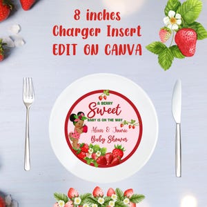 May include: A white charger plate with a pink and red circle in the center. The circle has a strawberry design with a baby girl holding a strawberry. The text reads "A Berry Sweet Baby is on the Way" and "Alexis & Jinario Baby Shower".